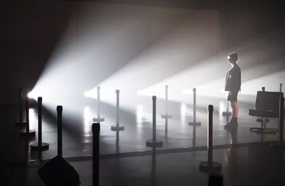 étudiante en contre-jour sur une scène parsemée de lumières 