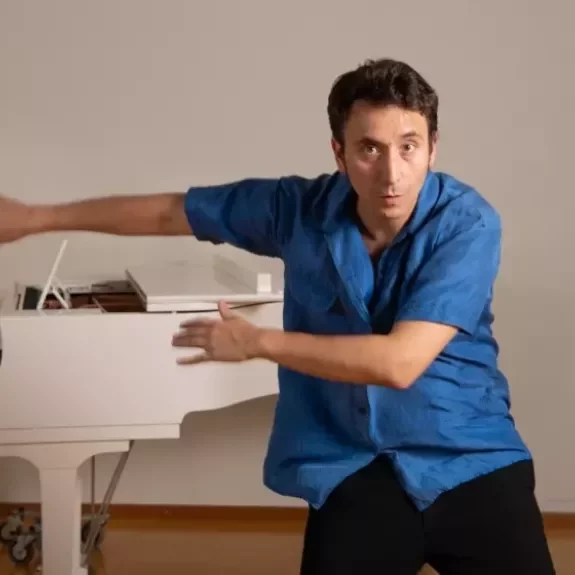 Personne en mouvement devant un piano blanc